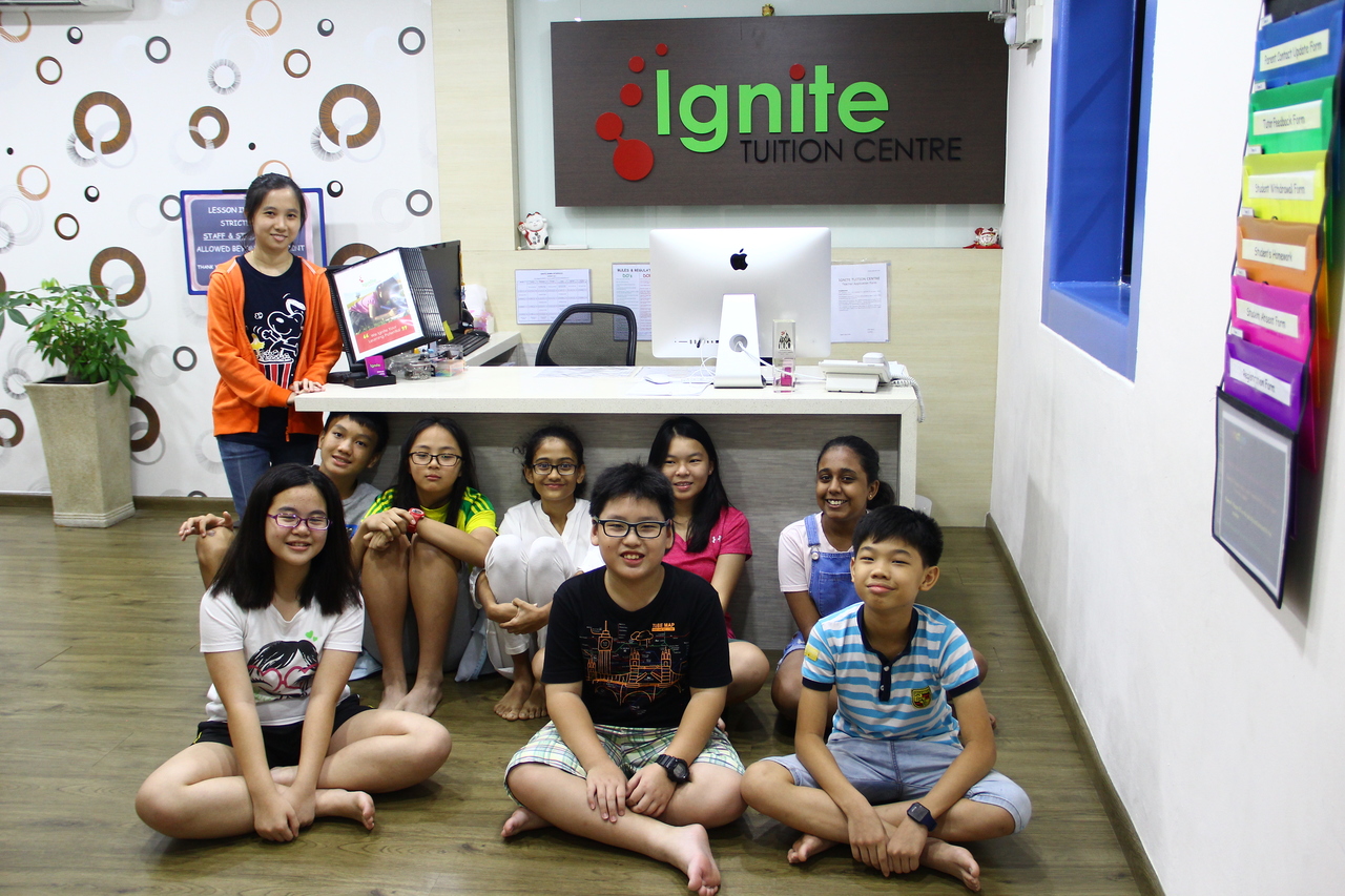 9 students sitting and smiling in the classroom of Ignite tuition centre